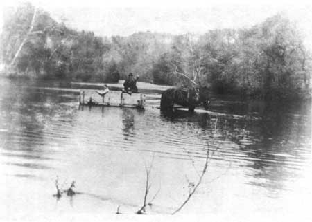 horse and wagon team crossing river